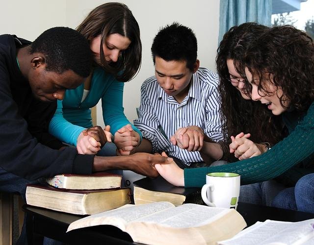 Un groupe en prière autour de la Bible